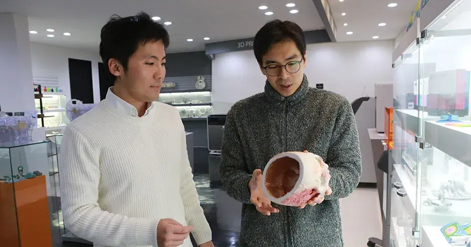 2 colleagues looking at a 3D print