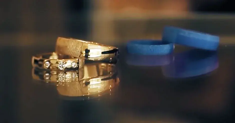 a gold ring sitting next to a 3D printed mold